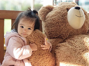 An image of a child cuddling a Vermont Teddy Bear