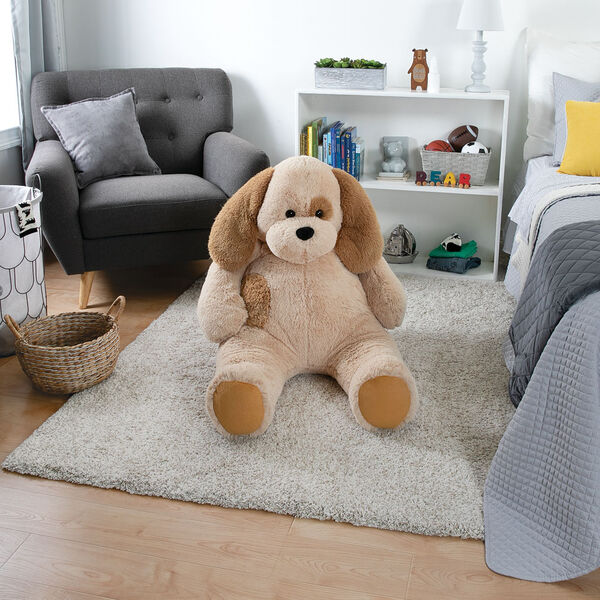 4' Cuddle Puppy - Front view of seated tan plush puppy in a living room scene