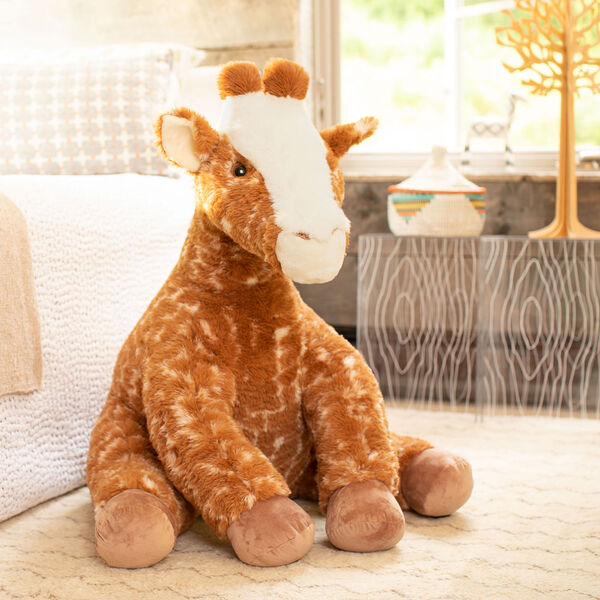 3 1/2' Gentle Giant Giraffe - Three quarter view of seated soft giraffe in bedroom scene image number 2