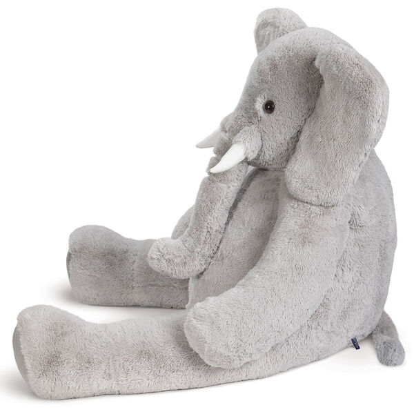 6' Giant Cuddle Elephant - Side view of seated grey plush elephant with white fabric tusks, floppy ears, long trunk and tail image number 6