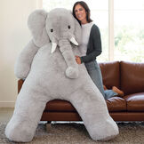 6' Giant Cuddle Elephant - Front view of seated grey plush elephant with model in a living room scene image number 0