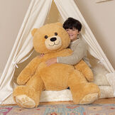 4' Boo The Loveable Big Teddy Bear - Seated light butterscotch brown bear in a bedroom scene with model image number 1