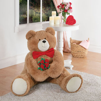 4' Big Hunka Love Bear with Bow Tie and Roses- front seated view of honey brown bear with a red velvet bow tie and red velvet fabric roses in a living room