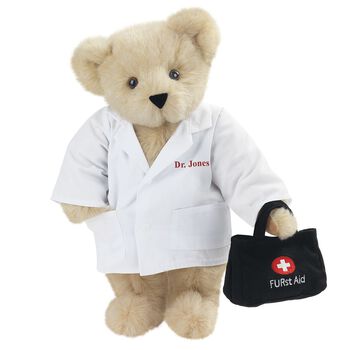 15" Doctor Bear - Front view of standing jointed bear dressed in white labcoat holding a doctor bag that is embroidered wth "FURst Aid" and a medical cross in red and white personalized with "Dr. Jones" on left chest in red - Buttercream brown fur