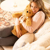 20" World's Softest Bear - Golden brown bear with ivory bow in living room scene with model image number 1
