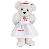 15" Nurse Bear - Front view of standing jointed bear dressed in white nurse's dress and hat with red trim perosnlized with "Kim RN" on bib of dress in red - Vanilla white fur image number 2